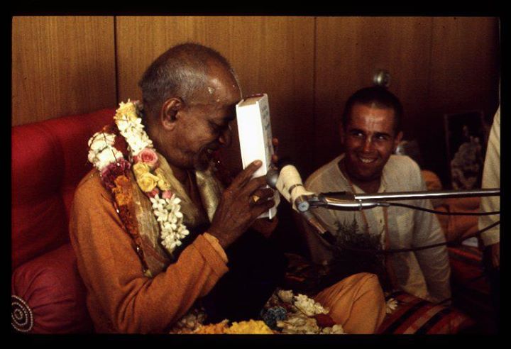 Śrīla Prabhupāda holding a book